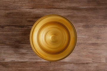 Mock up of rounded empty golden vase plate from top view on wooden rustic background