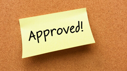 approved word written on a note sticky on corkboard