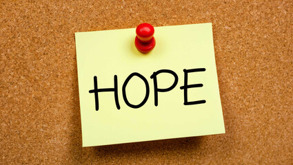 hope word written on a note sticky on corkboard