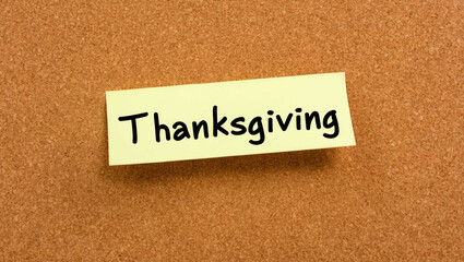 thanksgiving word written on a note sticky on corkboard