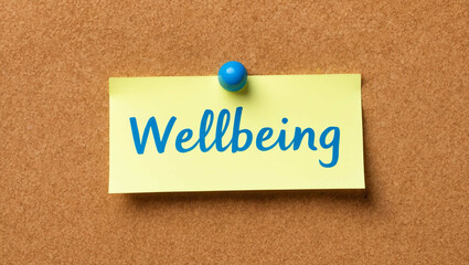 wellbeing word written on a note sticky on corkboard