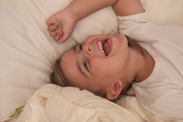 the little girl playing and tickling on the bed and having fun