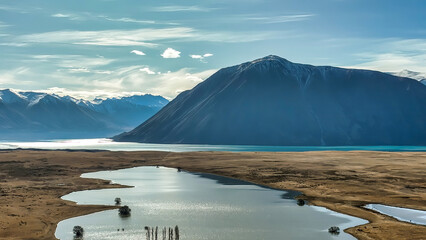 The way to Lake Ohau and the southern alps through alpine grasses and tundra terrain