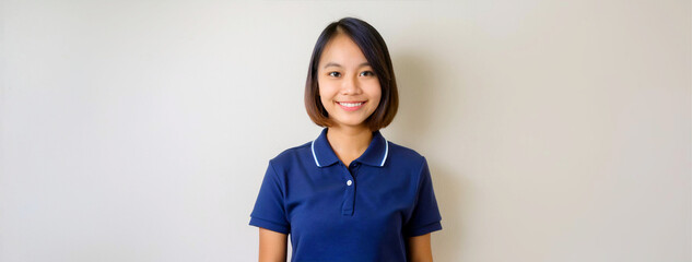 A Southeast Asian female staff member wearing a navy blue polo shirt