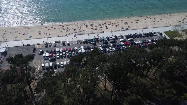 Aerial view of Playa de Samil, the main beach of Vigo in Galicia in northwest Spain. Sunny day, crystal clear blue sea. Houses, streets. Drone take.