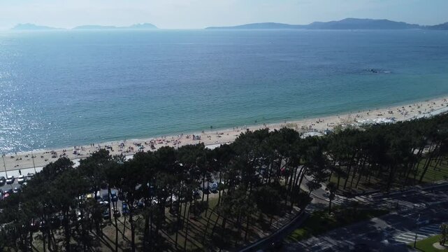 Aerial view of Playa de Samil, the main beach of Vigo in Galicia in northwest Spain. Sunny day, crystal clear blue sea. Houses, streets. Drone take.