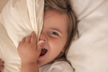 the little girl playing and tickling on the bed and having fun