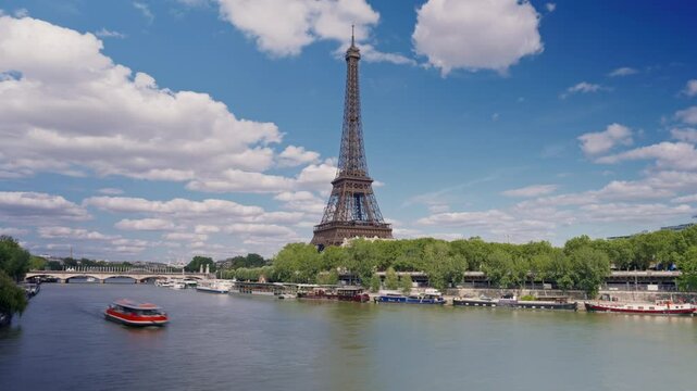 Timelapse of the Eiffel Tower along the river Seine with flyboats passing by with motion blur. Sunny but cloudy spring summer day paris city famous riverside bay tower view bridge time lapse panorama