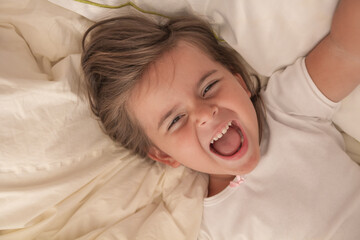 the little girl playing and tickling on the bed and having fun