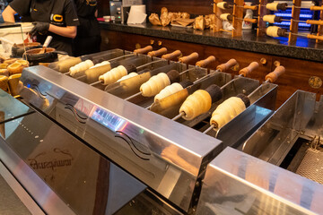 The chimney cake inside a shop in Prague, Czech Republic. The chimney cake
(trdelnik) is baked wrapped around a hot iron tube over a hot coal 