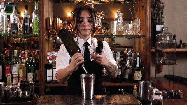 Female bartender preparing a cocktail in a traditional cocktail bar