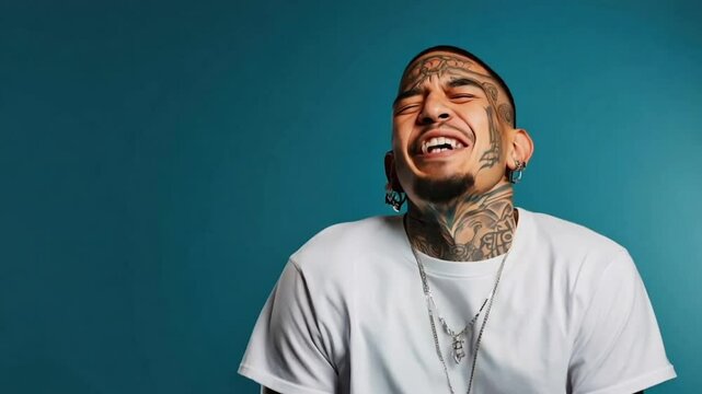 Young Latino man with face and neck tattoos laughing