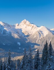 Majestic snow-capped mountain peaks under a clear blue sky in winter