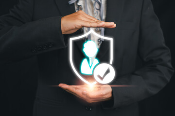 Businessman in a suit holding a digital shield icon representing consumer protection and security,...