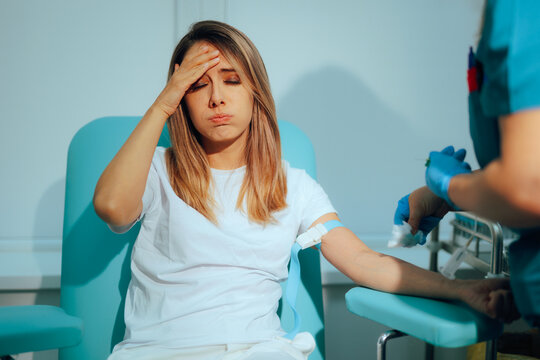 Stressed Woman Gets Blood Tests and is Fearful of the Needle. Patient feeling nauseated after blood draw test in a laboratory 
