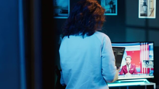 Woman walking in apartment designing and developing software applications using laptop. IT professional standing in living room, implementing and maintaining company systems, camera A