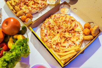 An indoor office party scene with no people around, featuring a desk filled with food pizza, bread,...