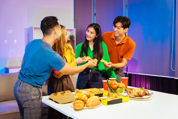 A group of Asian friends gathers in an office for a night of BBQ, pizza, and drinks, celebrating Halloween with vibrant RGB lighting, laughter, and cheering for their favorite soccer team.