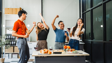 Asian office colleagues and friends enjoy a daytime BBQ with pizza and beer, celebrating Halloween and cheering for their favorite soccer team, creating a lively atmosphere filled with joy.