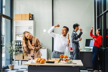 Asian office colleagues and friends enjoy a daytime BBQ with pizza and beer, celebrating Halloween and cheering for their favorite soccer team, creating a lively atmosphere filled with joy.