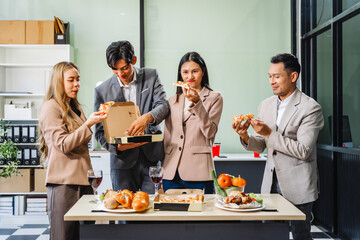 Asian office colleagues and friends enjoy a daytime BBQ with pizza and beer, celebrating Halloween and cheering for their favorite soccer team, creating a lively atmosphere filled with joy.