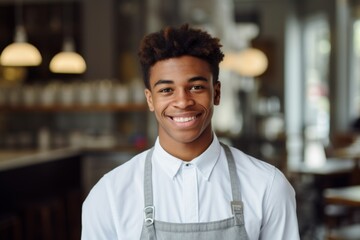 Fototapeta premium Portrait of a smiling young male barista in cafe