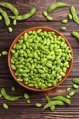 Raw green edamame soybeans and pods on wooden table, flat lay