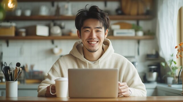 Modern worker in selfisolation home office and work during covid19 quarantine Smiling young asian male with cup drinking coffee and working on laptop at table in kitchen interior free  : Generative AI