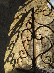 Wrought-iron grille with shadow effect on a wall - Grille en fer forgé avec effet d'ombre sur un mur