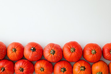 Obraz premium Hokkaido pumpkins arranged in a neat border, showcasing their vibrant orange color and unique shape on a plain background