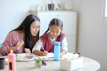 Portrait Of Mother Supporting Daughter Doing Homework