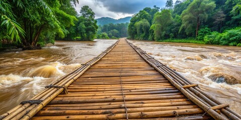 Bamboo bridge over swollen river in lush rain-soaked forests of northern Thailand