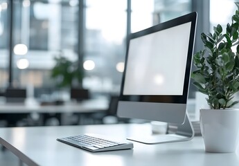 Fototapeta premium White desk with computer and office background blurred in the foreground,workspace