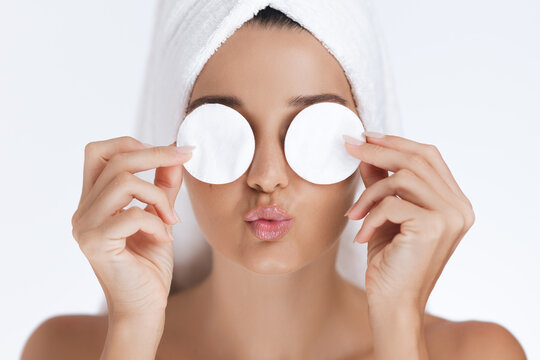 Woman Playfully Covering Eyes with Cotton Pads During Skincare Routine