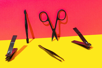 Essential Black Manicure Tools on Vibrant Red and Yellow Background