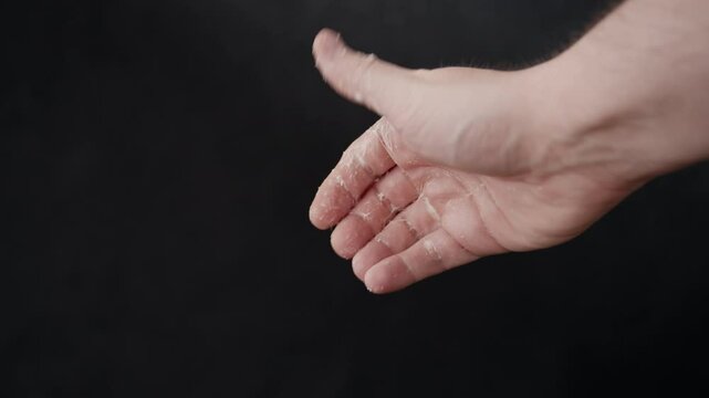 Hand covered in a sticky white slime. Isolated male hand opens a fist stretching the sticky goo strands.