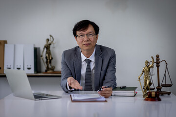 A senior man lawyer conducts an online consultation from a laptop via video link for a client. work in a law firm checking documents or contracts via the Internet. european senior adul lawyer.