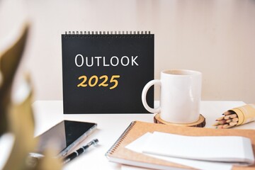 Outlook 2025 inscription on blank calendar on office desk. Forecast, expectations, predictions for the year 2025 concept.