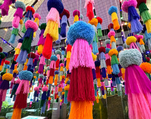 Naklejka premium Series of colorful hanging tassel based on Thailand culture and ethnic arts. Rainbow color of tassel pom pom hanging down from ceiling.
