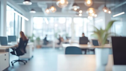 Blurred office space with people working on computers.