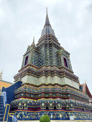 Fototapeta premium Series of pagoda and chedi made of crafted and sculpted stone, painted in many colors and made of decorative ornaments. Wat Pho pagoda complex, Bangkok , Thailand.