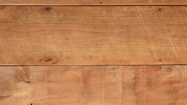 video footage of the surface texture of a brown wooden board moving to the left