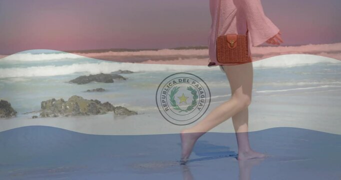 Paraguay flag animation over woman walking on beach with waves in background