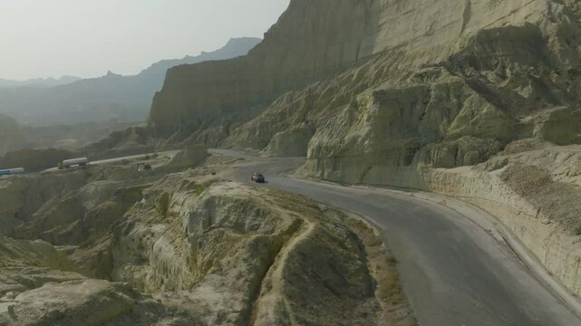 Drone view of a local Pakistani car passing through Buzi pass top in Makran coastal Highway at Balochistan , Pakistan.