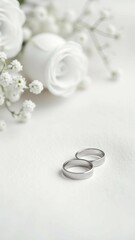 Elegant Wedding Rings with White Roses and Soft Floral Background