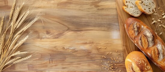 Fresh crispy bread and ears of wheat on a wooden countertop with copy space flat lay banner