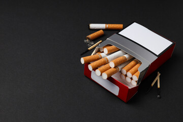 A pack of cigarettes with matches on a dark background