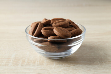 Cookies in the shape of coffee beans in transparent bowls