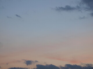 This image depicts a clear blue sky with white, wispy clouds. The sky is a vibrant blue color, contrasting with the lighter tones of the clouds. The clouds are thin and delicate, creating a sense of o