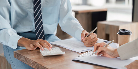 Strategic business meeting using calculator in a cafe